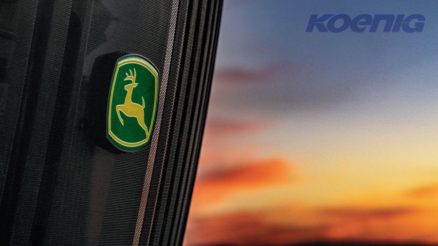 Close-up of a John Deere tractor hood against a sunset sky